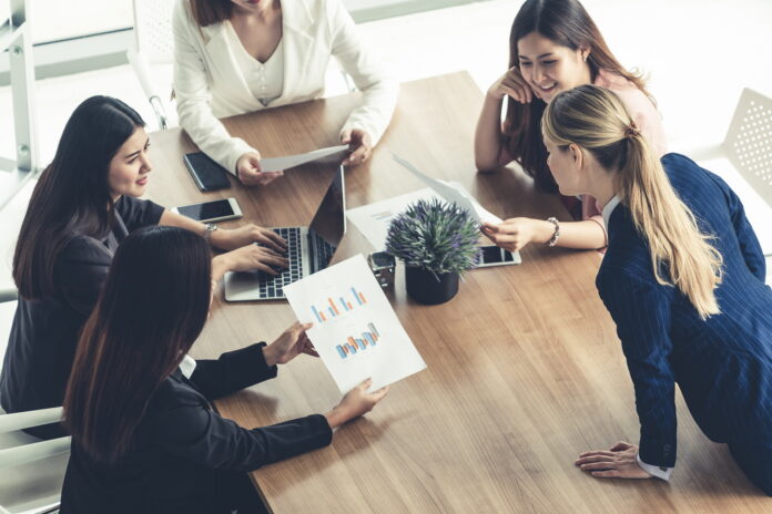 Businesswoman in group meeting discussion with other businesswomen.