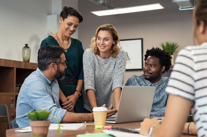 Businessman showing project and marketing strategy on laptop to colleagues.