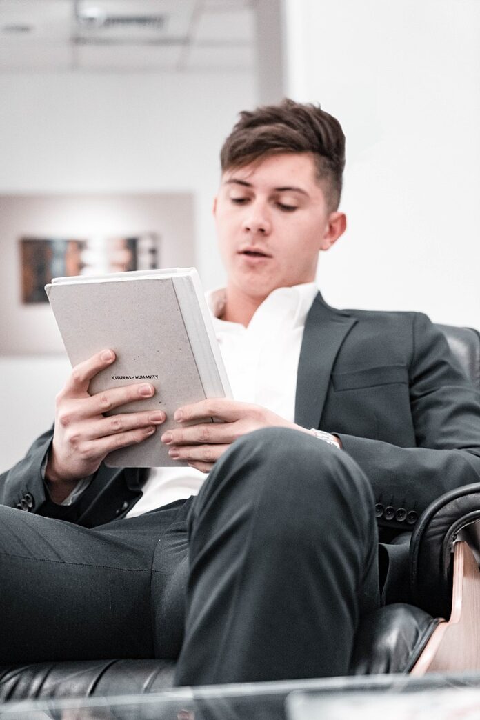 Robert Nagy, an Entrepreneur and Author, sitting while holding a book
