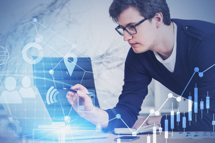 Young market analyst working with digital business interface.